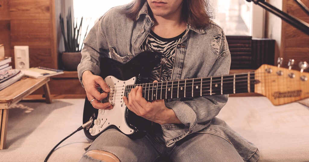 Un guitariste débutant avec sa guitare électrique